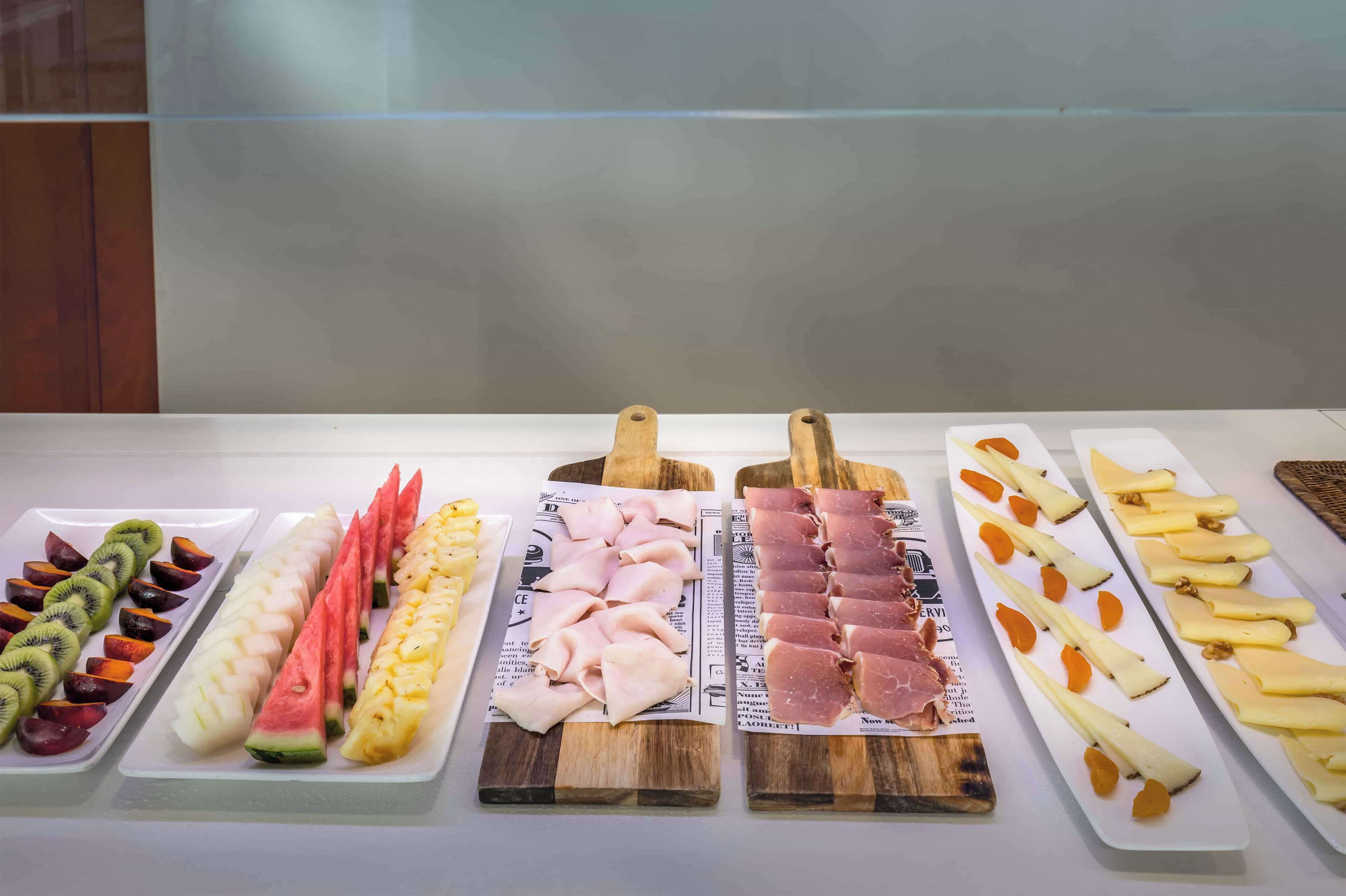 Diversos alimentos presentados sobre platos rectangulares blancos y tablas de madera.