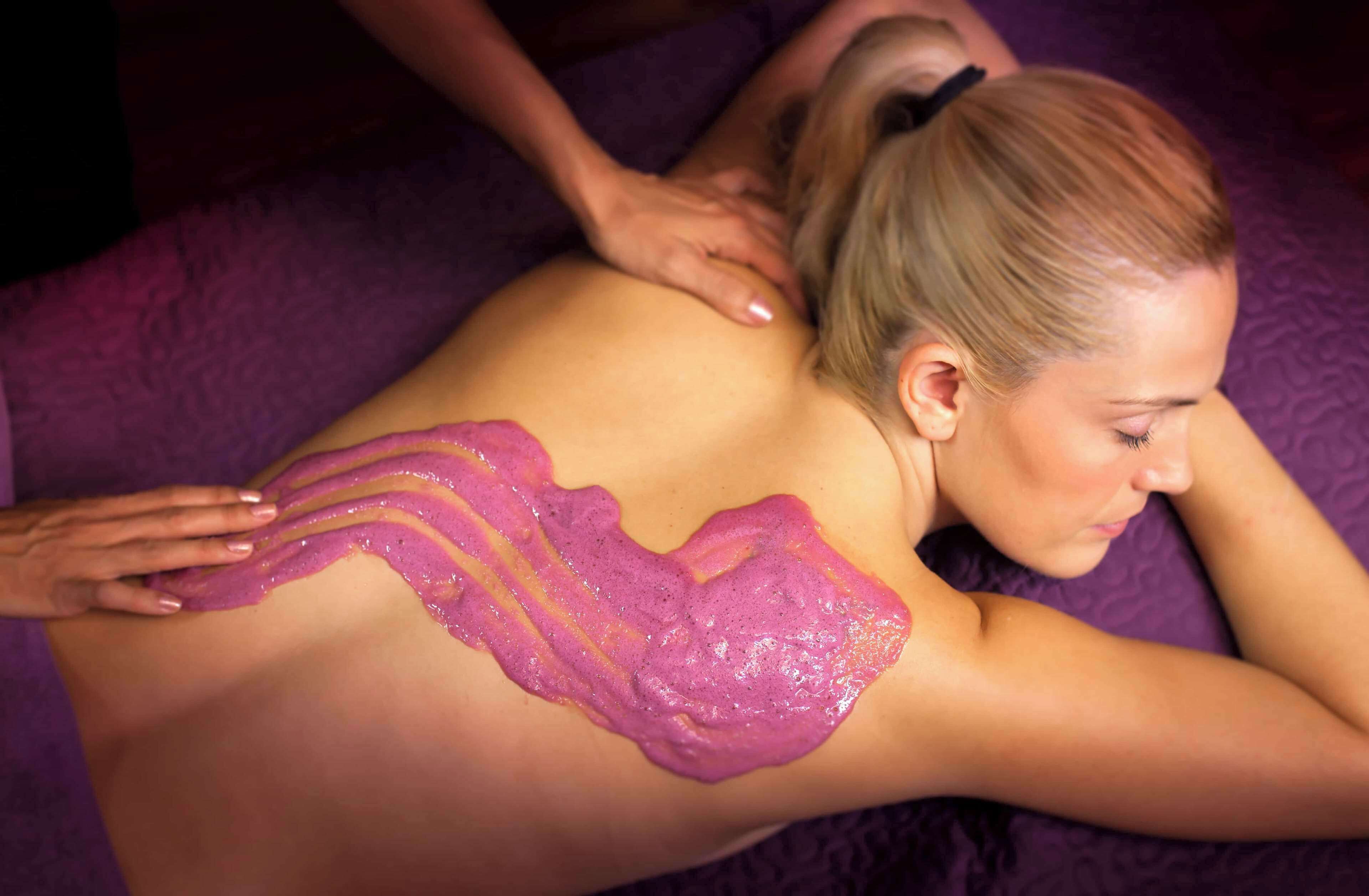 A person receiving a massage with a purple towel.