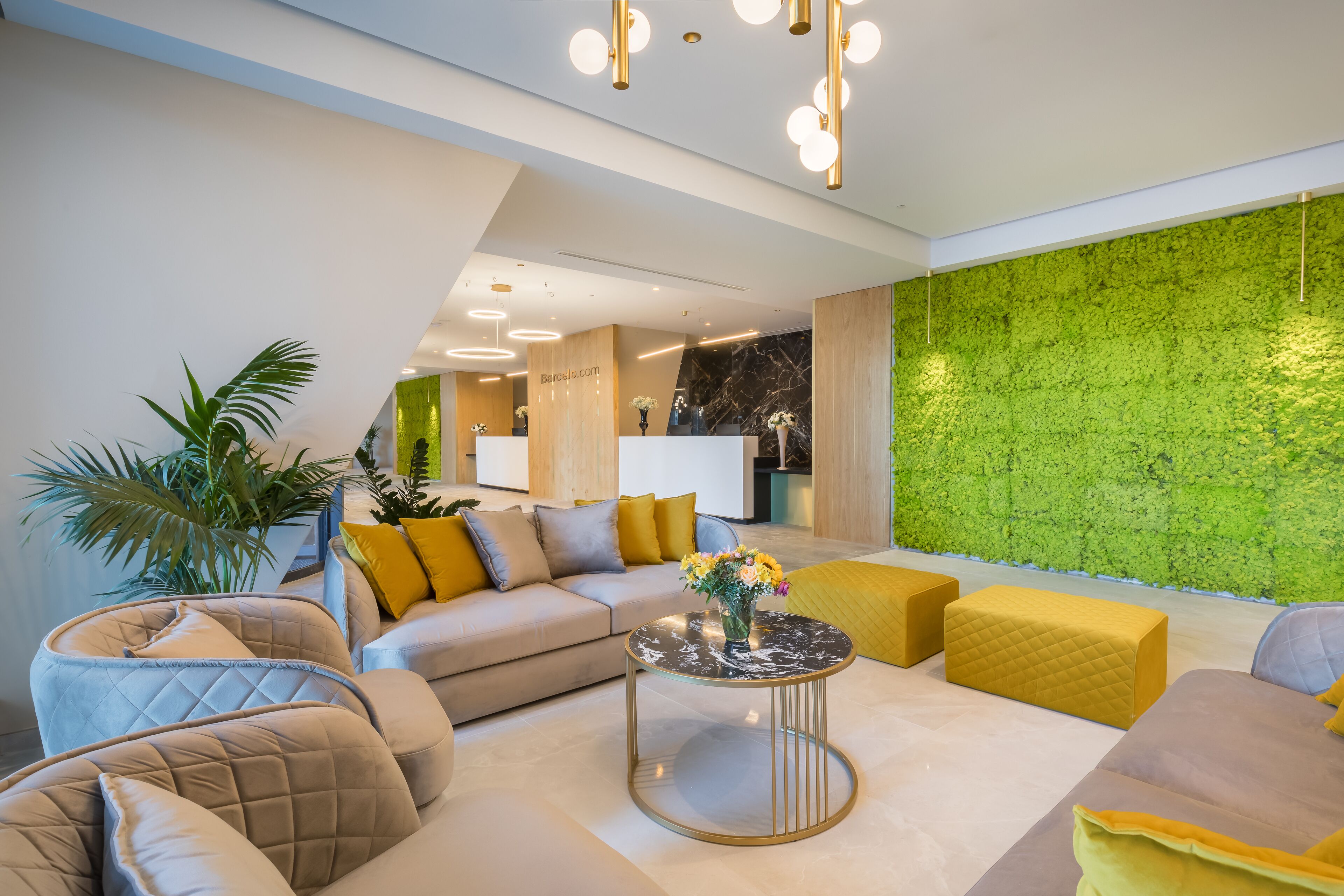 A modern living room with a sofa, ottoman, and a round coffee table.