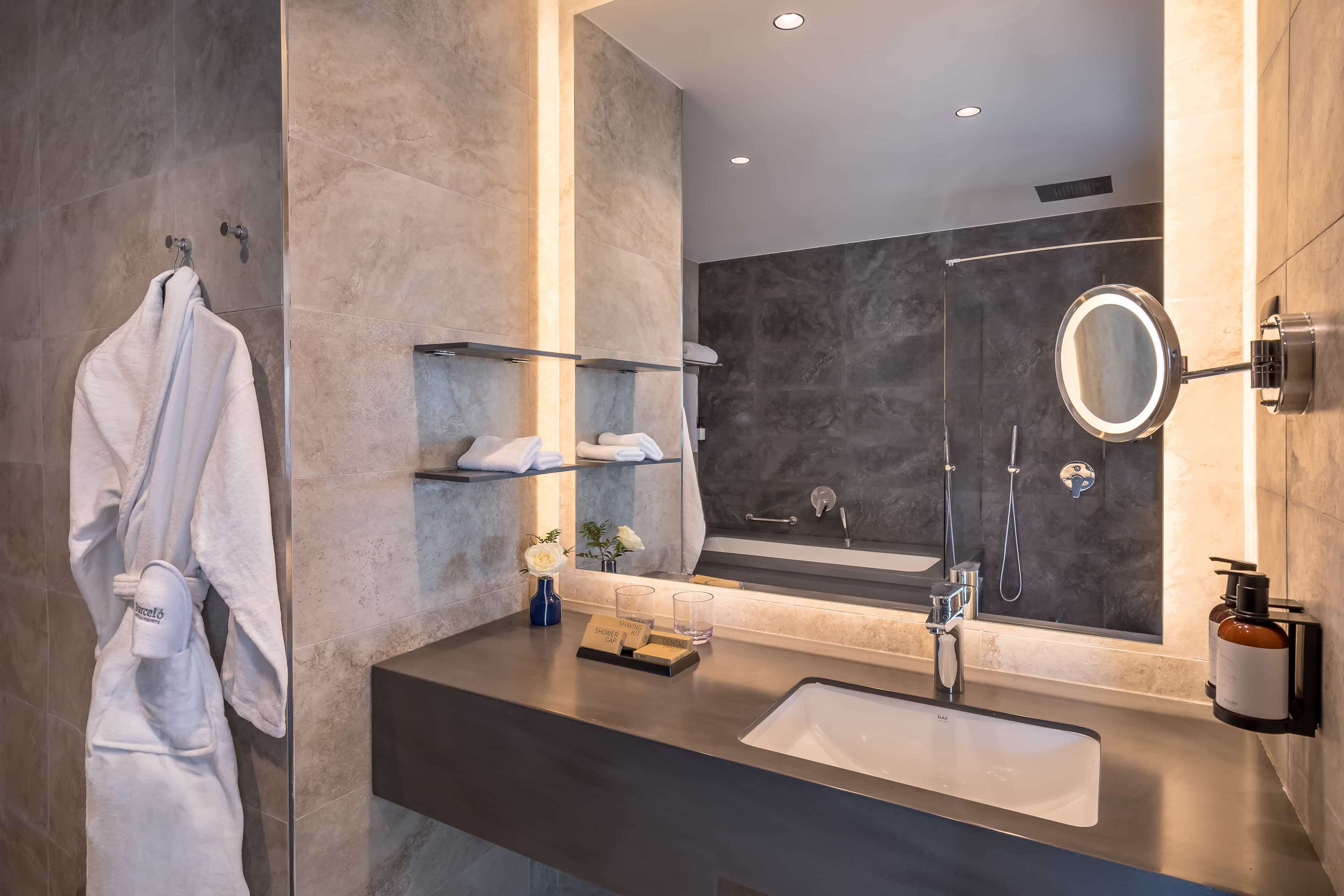Een moderne badkamer met een grote spiegel, een wastafel en een handdoekhouder.