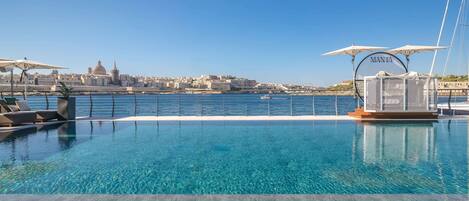 Una piscina cubierta, una piscina al aire libre, sombrillas, tumbonas