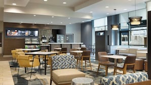 A modern hotel lobby with a bar area, seating arrangements, and a large window offering a view of the museum center. - Courtyard by Marriott Little Rock Downtown (Little Rock)