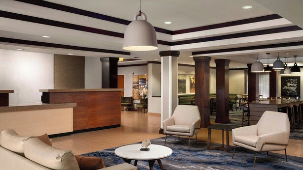 A lobby with a reception desk, seating area, and a bar. - Fairfield Inn & Suites by Marriott Tifton (Tifton)