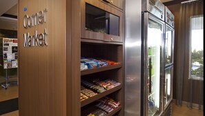 A corner market with shelves of snacks and a refrigerator. - Fairfield Inn & Suites by Marriott Tifton (Tifton)