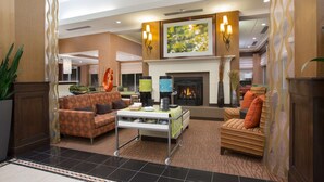 A spacious lobby with a fireplace, comfortable seating, and a coffee station. - Hilton Garden Inn Salt Lake City/Layton (Layton)