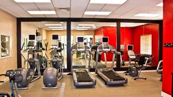 A gym with treadmills, elliptical machines, and weight equipment.