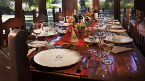 A dining table set for a meal with wine glasses, plates, and cutlery.