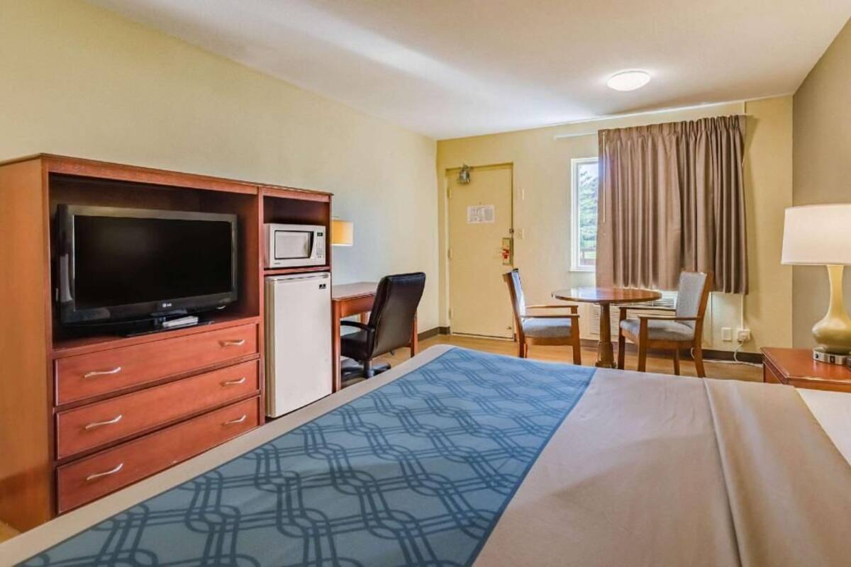 Une chambre d’hôtel comprenant un lit, une télévision, un bureau, une chaise et une table.