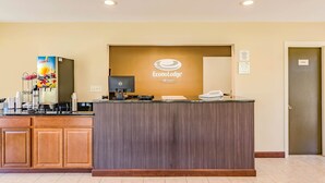 Un comptoir d’accueil avec une enseigne indiquant « Econolodge » et une machine à café.