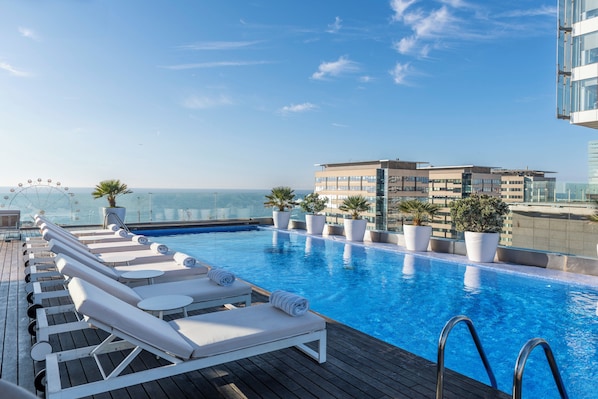 Een buitenzwembad en ligstoelen