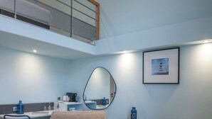 A modern living room with a high ceiling, a dining area, and a kitchen. - Best Western Alba Hotel (Nice)