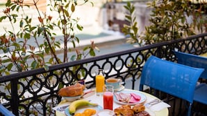 A balcony table with breakfast items, blue chairs, and a cityscape view. - Best Western Alba Hotel (Nice)