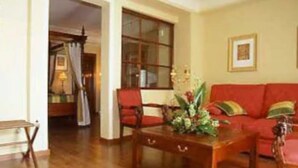 Una sala de estar con un sofá rojo, una mesa de centro de madera y un ventanal grande.