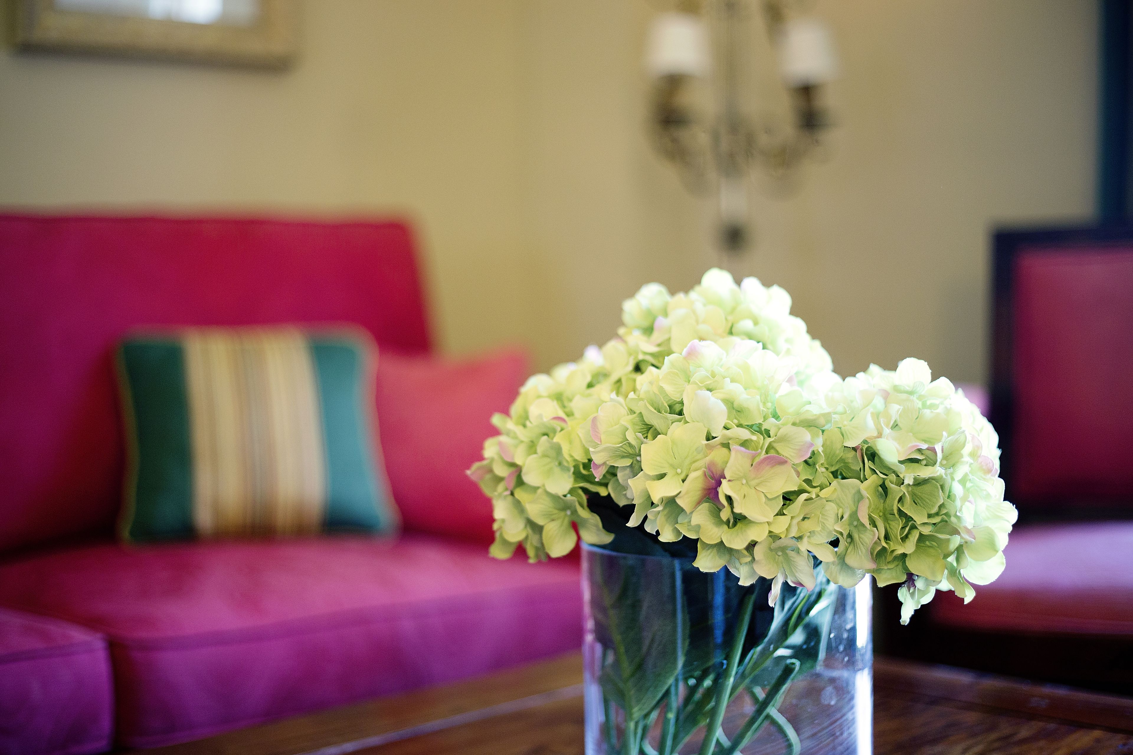 A clear glass vase with flowers on a wooden table.