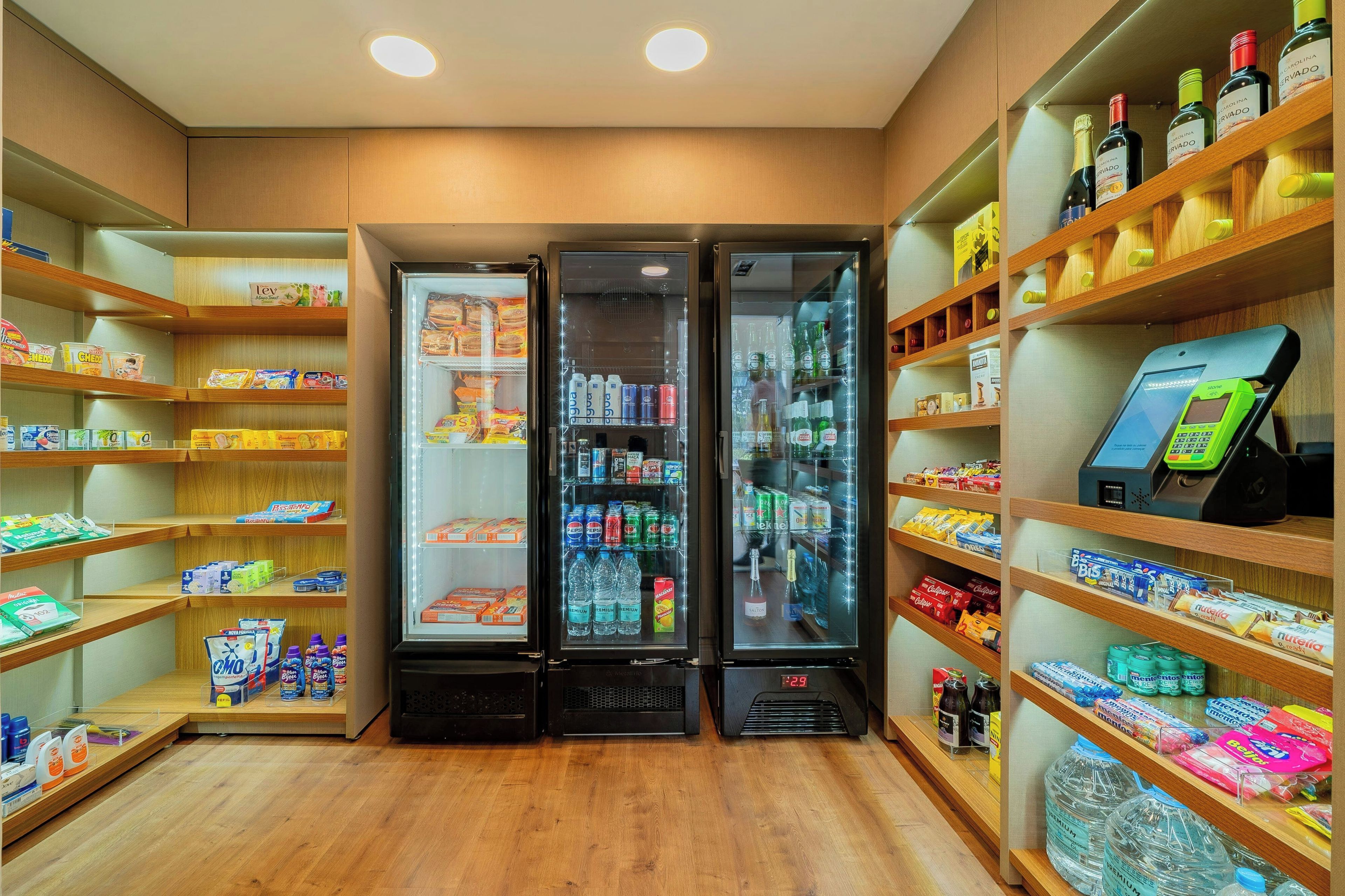 A store with shelves stocked with snacks, beverages, and a self-checkout machine.