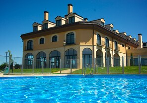 Un edificio grande con una piscina al frente.