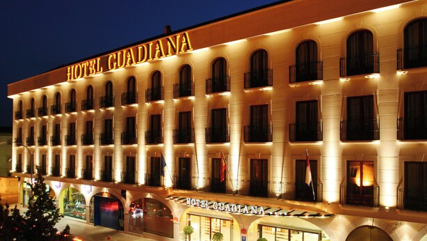 Un hotel de varios pisos con una fachada clásica, que presenta ventanas de arco y balcones.
