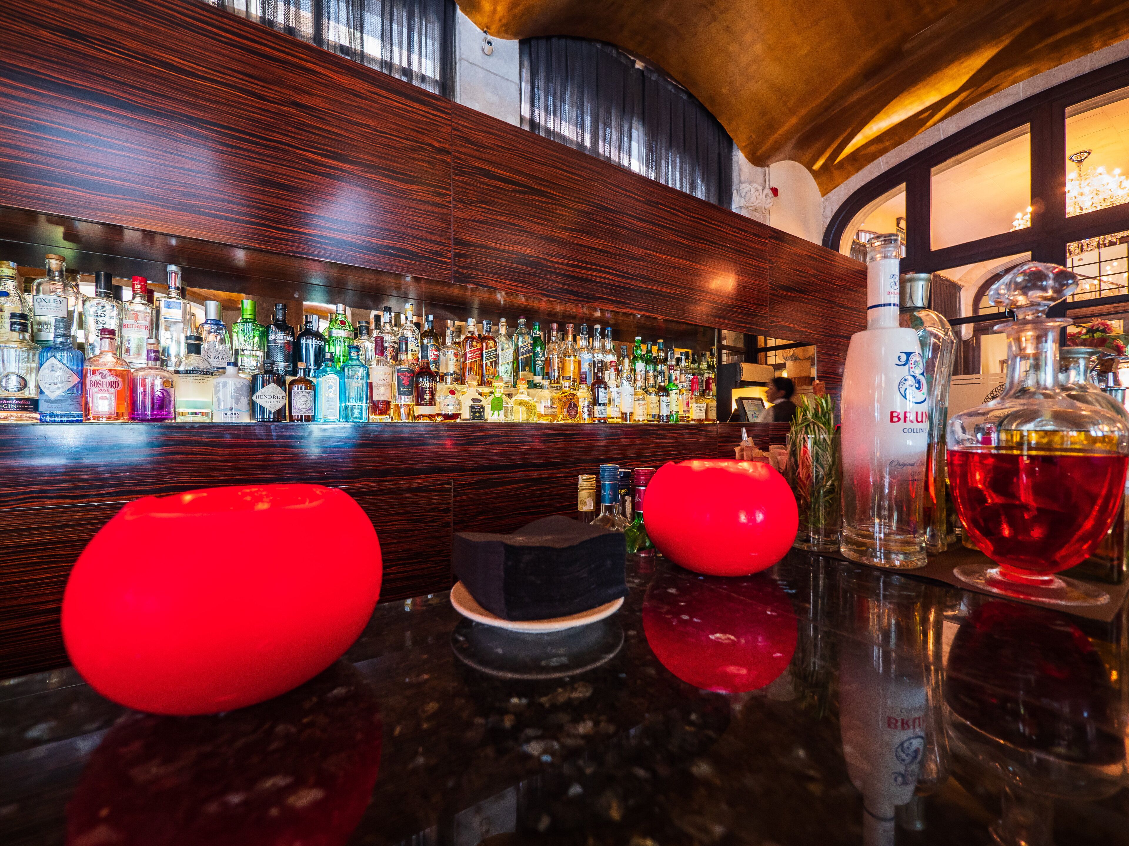 Un espace bar avec un assortiment de bouteilles d’alcool et quelques objets décoratifs disposés sur le comptoir.