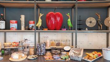 Una encimera de cocina con diversos alimentos, utensilios y objetos decorativos.