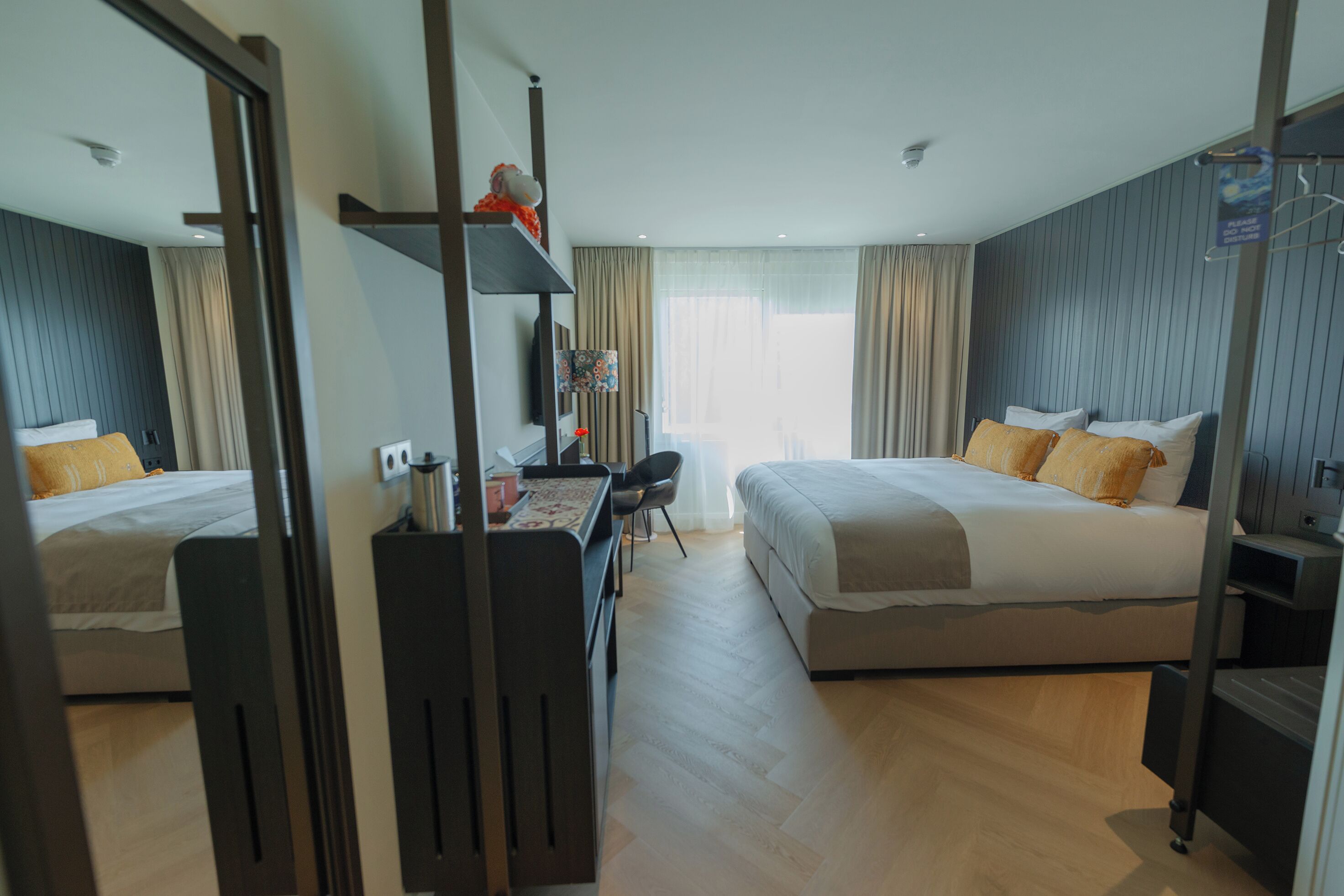 Une chambre d’hôtel moderne avec deux lits, un bureau et une chaise.