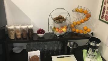 A kitchen counter with various food items, a coffee maker, and a cutting board.