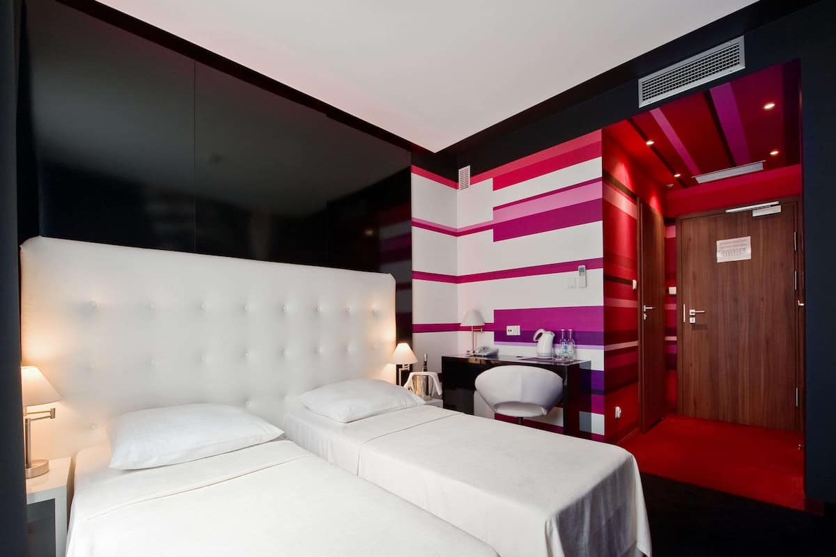 Una habitación de hotel con dos camas, un escritorio y una silla.