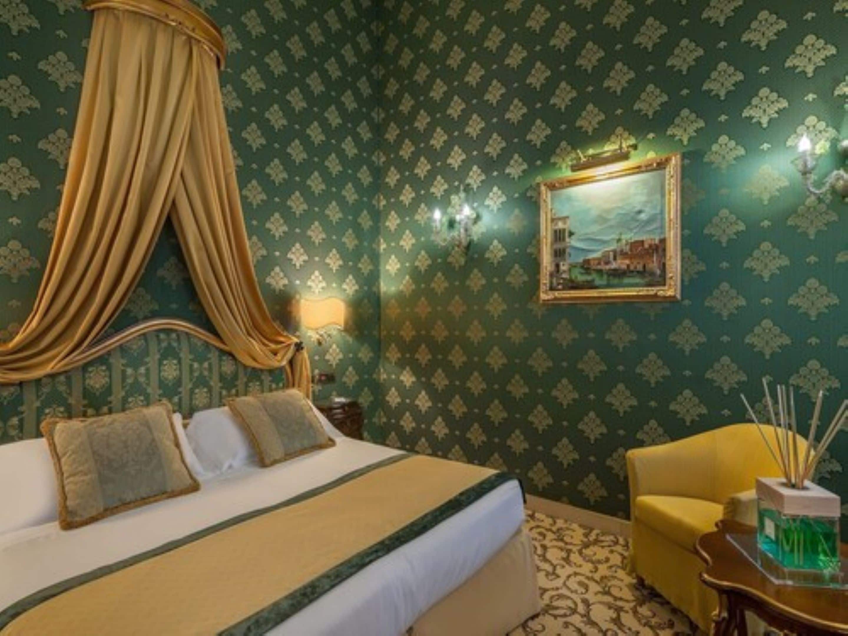 A room with a four-poster bed, a painting on the wall, a lamp, and a chair.