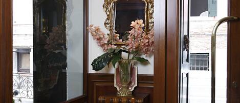 Une porte en bois avec un miroir et un vase de fleurs.