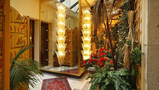 A grand hallway with a red carpet, a glass ceiling, and a mirrored wall reflecting the lights. - Ca' Dei Conti (Venice)
