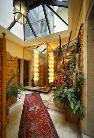 A grand hallway with a red carpet, a glass ceiling, and a mirrored wall reflecting the lights.