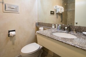 Un bagno con servizi igienici, lavandino e specchio.
