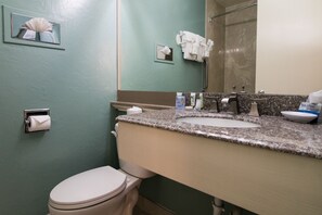 Un bagno con il water, lavandino e specchio.