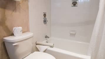 A bathroom with a toilet, a bathtub, and a shower.