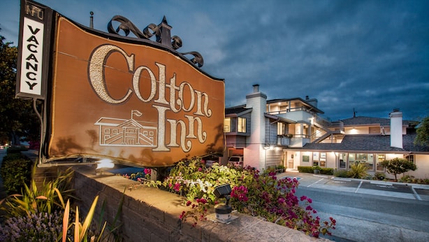 Señal del Cotton Inn con vista clara del exterior del edificio y un estacionamiento.
