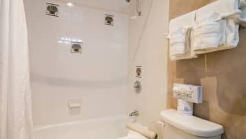 A bathroom with a bathtub, toilet, and towel rack.