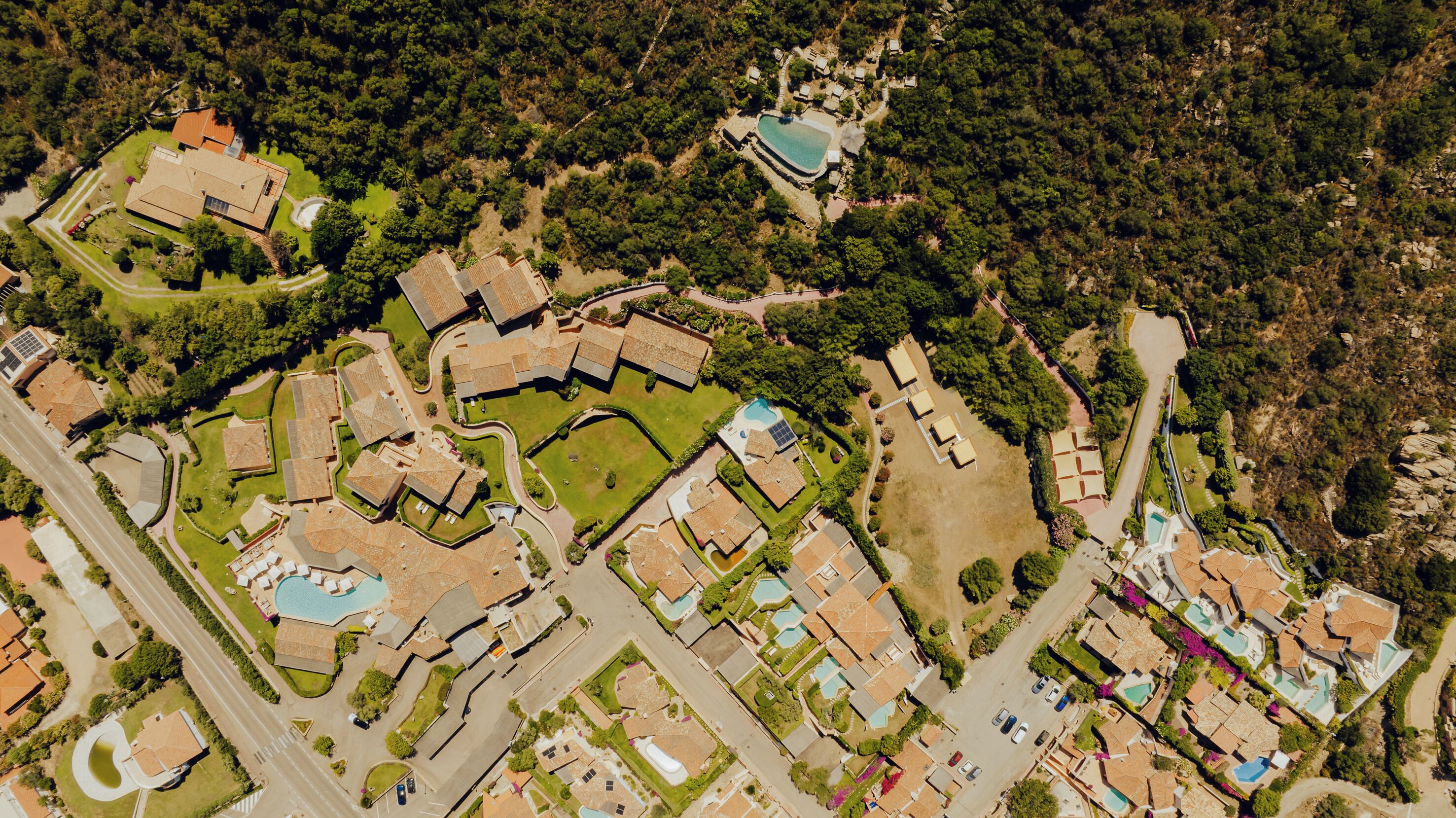 An aerial view of a residential area with multiple houses, roads, and green spaces.