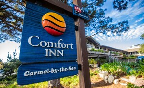 A blue sign for Comfort Inn with a basketball and a "Carmel-by-the-Sea" label. - Comfort Inn Carmel By The Sea (Carmel)