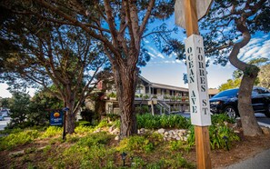 A street sign for Ocean Street, a building with a balcony, and a parked car. - Comfort Inn Carmel By The Sea (Carmel)
