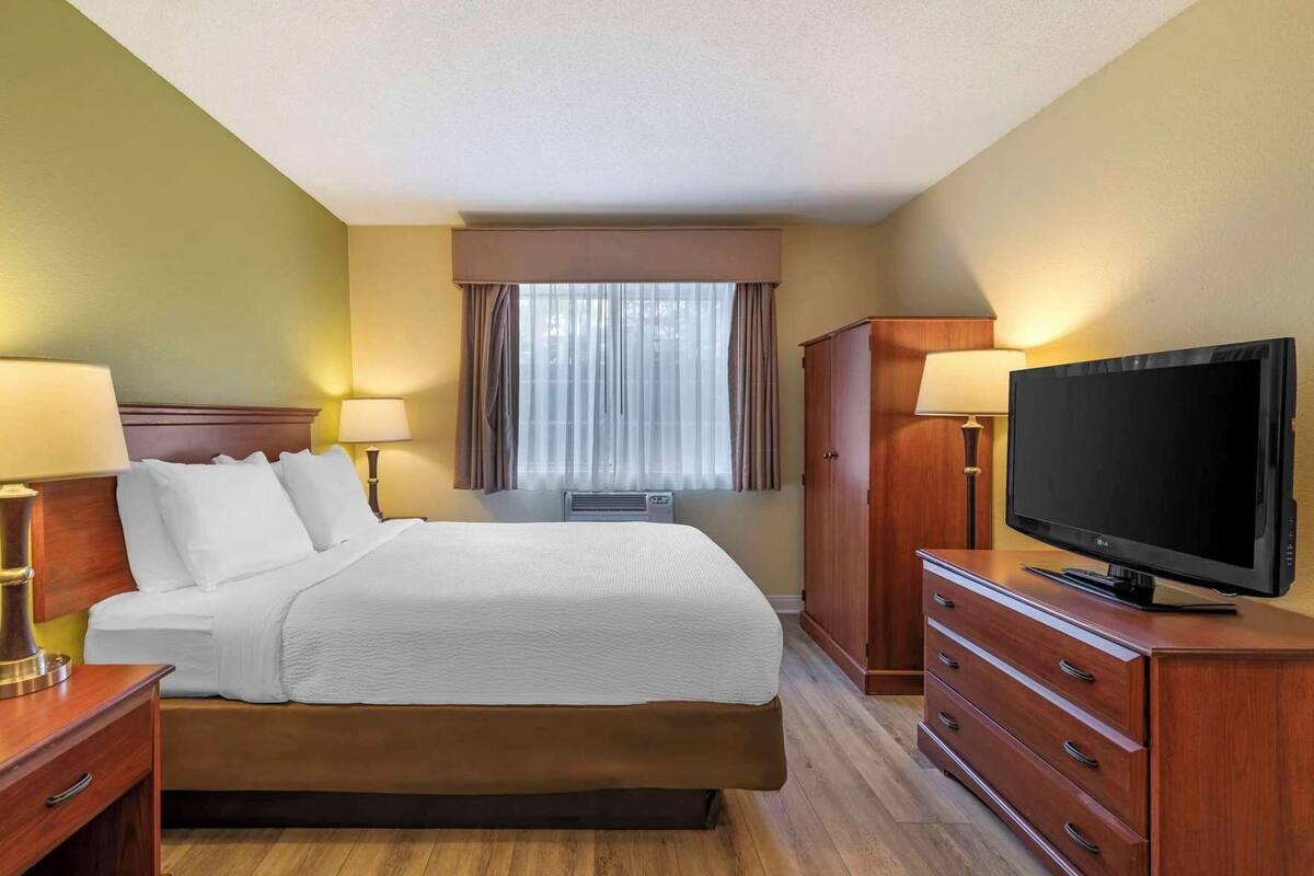 Roupas de cama premium, escrivaninha, espaço de trabalho para notebook