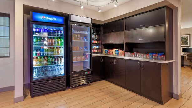 A vending area with Pepsi and Coca-Cola coolers, snack dispensers, and a counter with packaged goods. - Best Western York Inn (York)