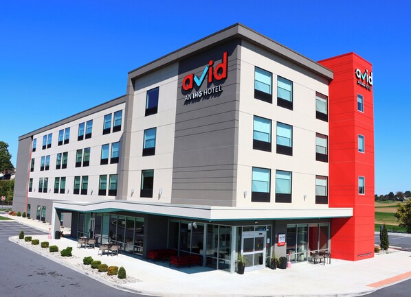 A modern hotel with a flat roof, large windows, and a prominent red and white color scheme.
