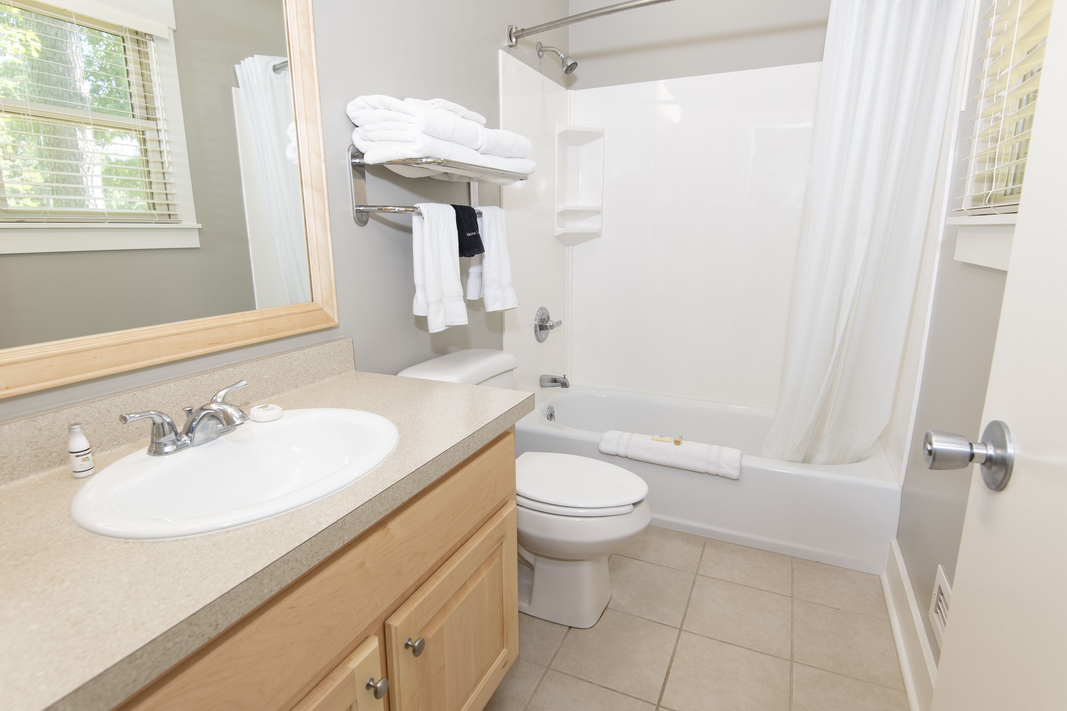 A modern bathroom with a sink, toilet, and bathtub.