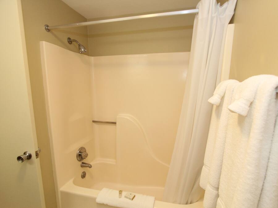 A bathroom with a bathtub, a shower curtain, and a towel rack.