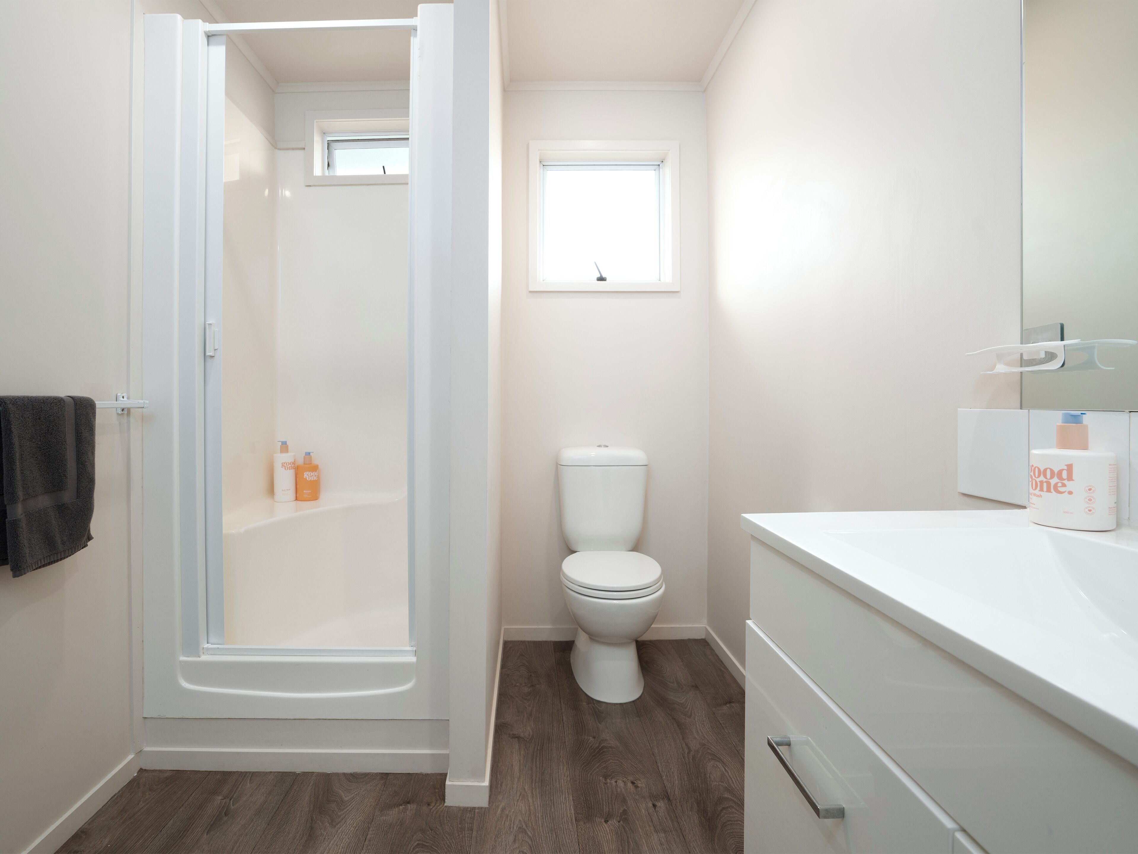 Un baño moderno con cabina de ducha, inodoro y zona de lavamanos.