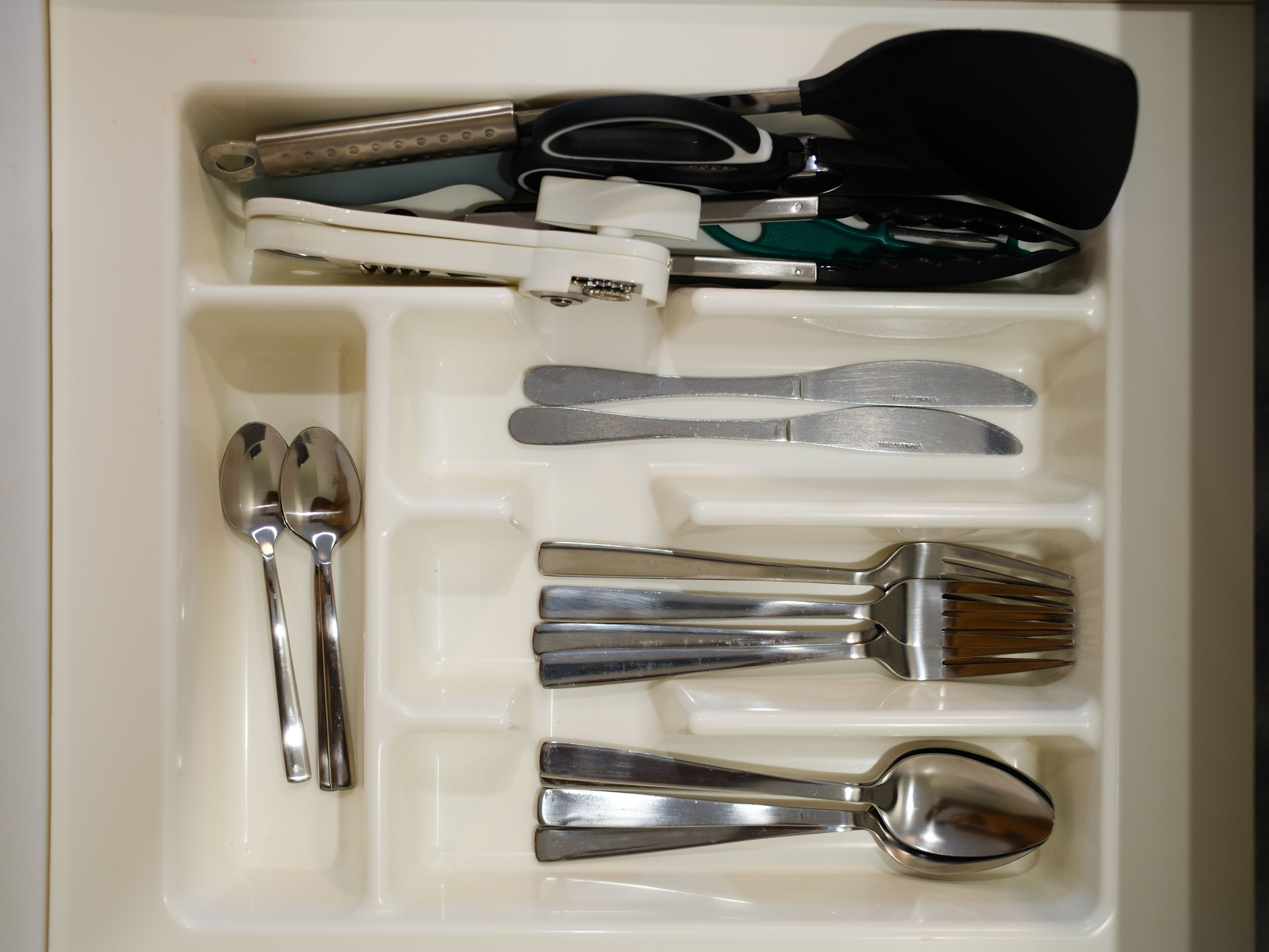 A drawer with utensils including forks, knives, and spoons.