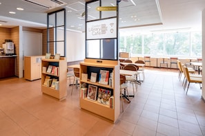 A library cafe with bookshelves, tables, and chairs.