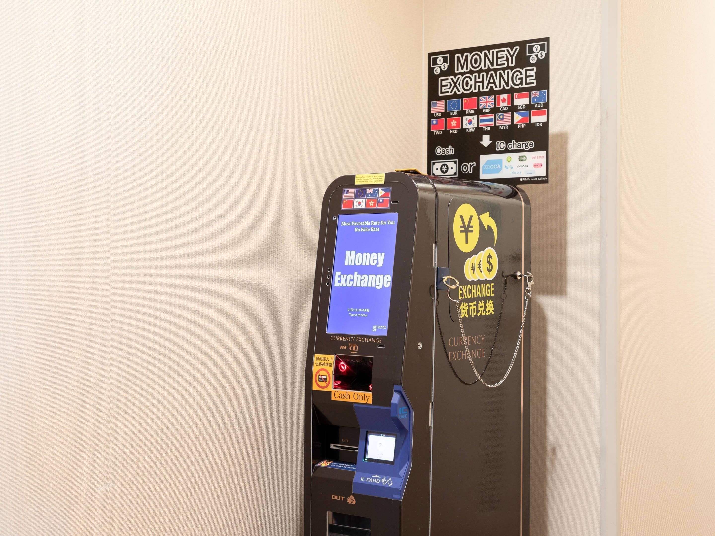 A currency exchange machine with a digital display, cash and card payment options, and a sign indicating the currencies it accepts.