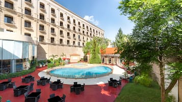 Una piscina al aire libre, sillones reclinables de piscina