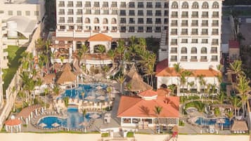 Um resort com vários edifícios, uma praia e uma área de piscina.
