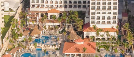 A resort with multiple buildings, a beach, and a pool area.